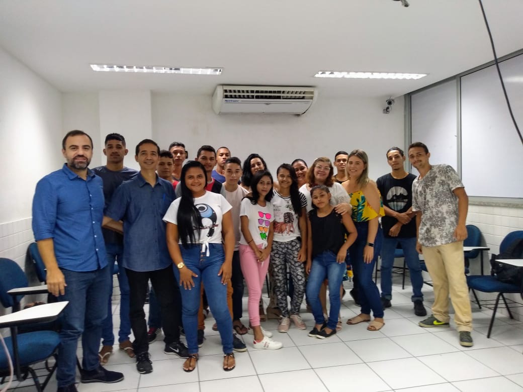 grupo de pessoas em pé na sala de aula posando para a foto